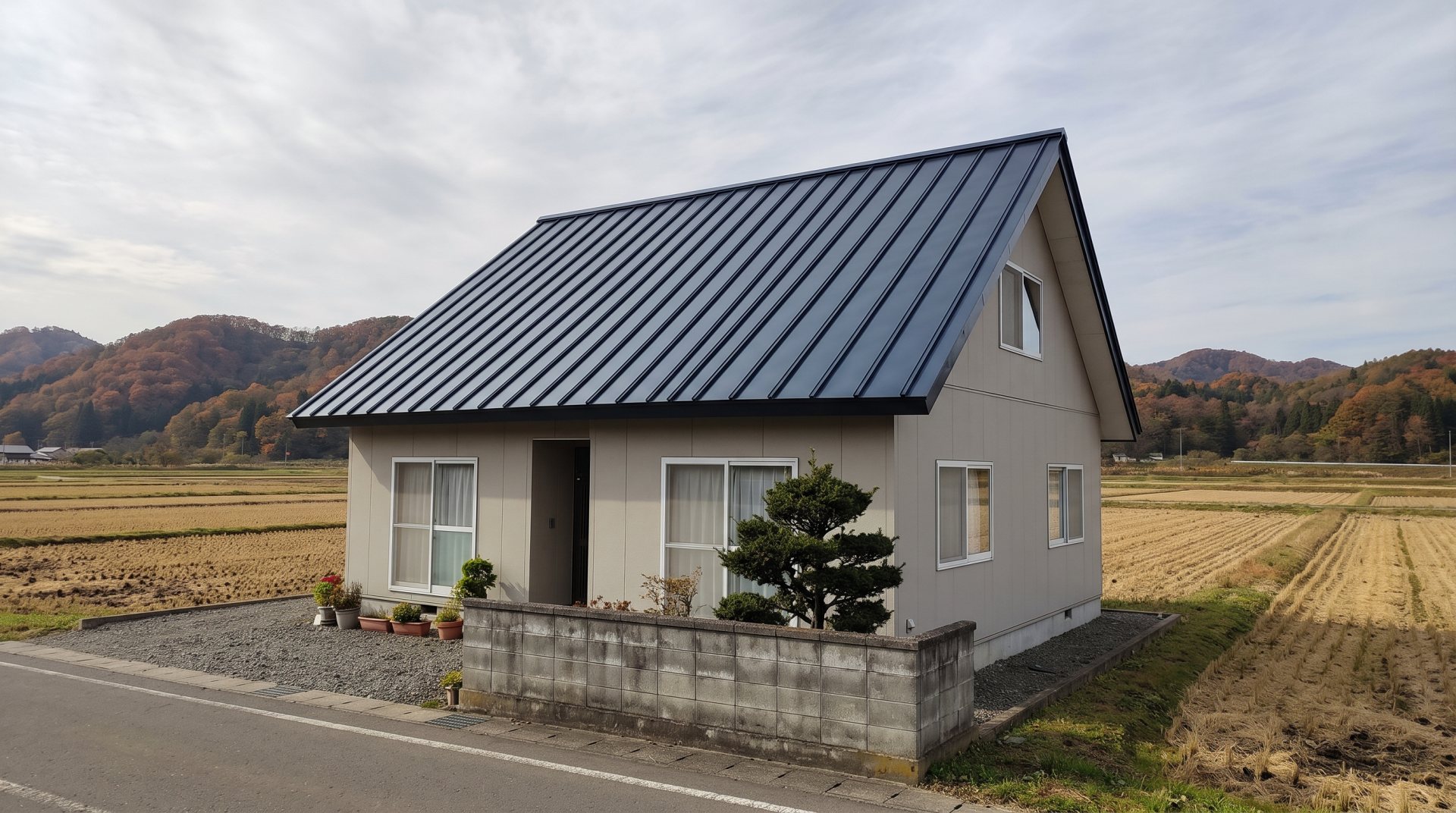 黒い金属屋根の家と、田んぼと山（見本の画像）